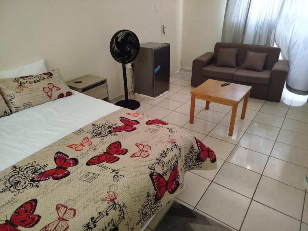 a bedroom with a bed with a blanket with butterflies on it at Manor Rentals in Potchefstroom
