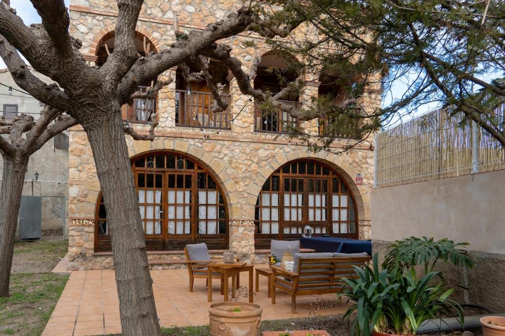 a patio with a table and chairs in front of a building at Casa rural La Plana in Alcover