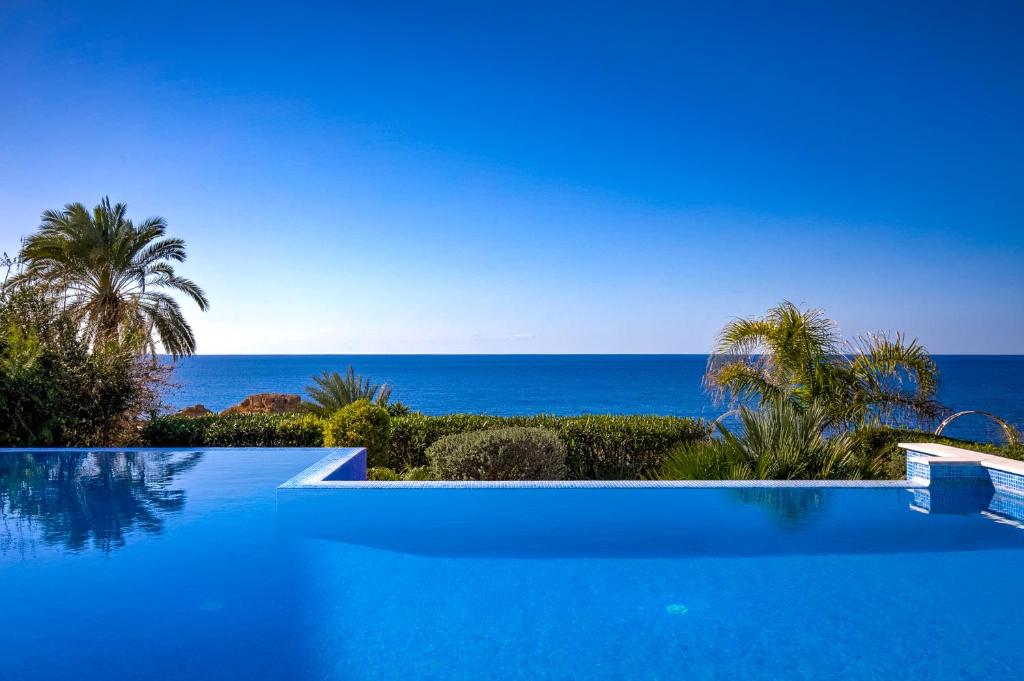 a swimming pool with a view of the ocean at Olymp Luxury Villa А - Beachfront Luxury Living in Kissonerga
