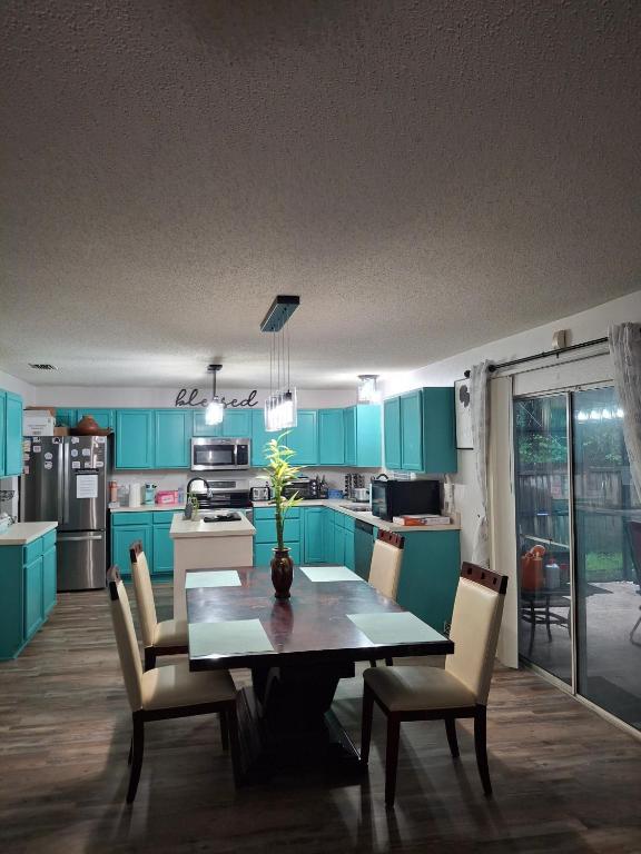 a kitchen with blue cabinets and a table and chairs at A&D Homes Peaceful Retreat in Jacksonville