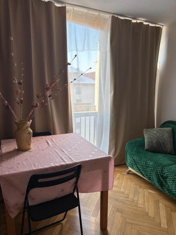 a pink table and chair in a room with a window at Zakątek in Warsaw