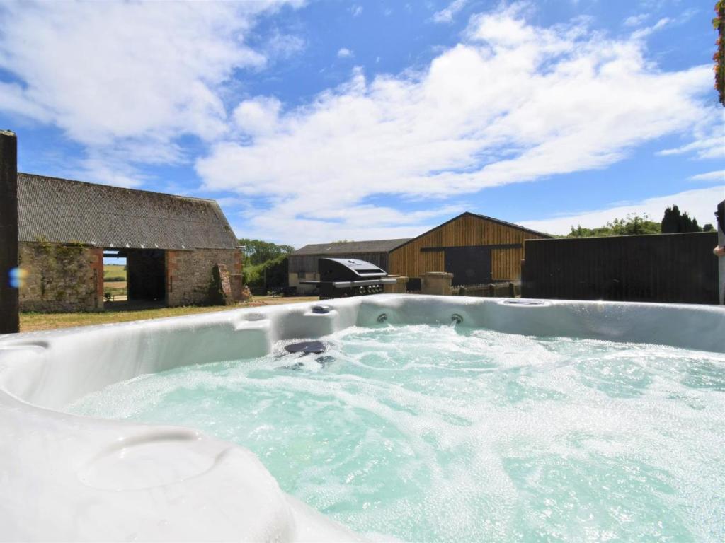 a hot tub in a yard with a building at 2 Bed in Ventnor oc-88857 in Niton