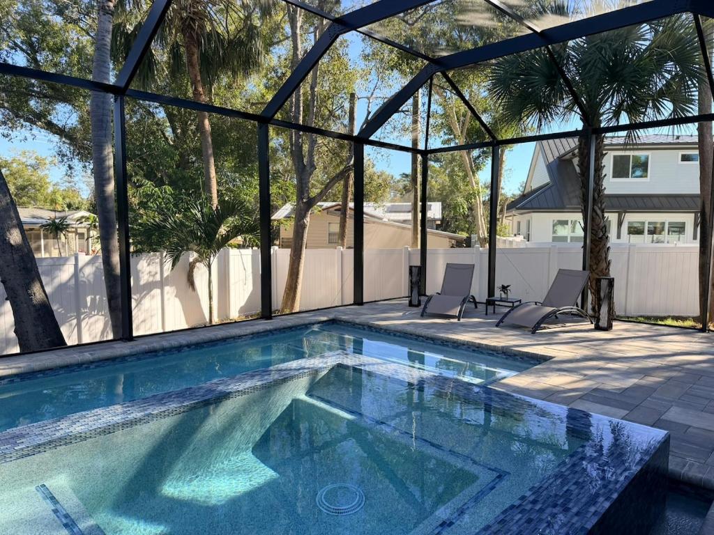 a swimming pool with two chairs in a house at New Upscale & Modern Heated Pool Home in Walkable Downtown! in Sarasota