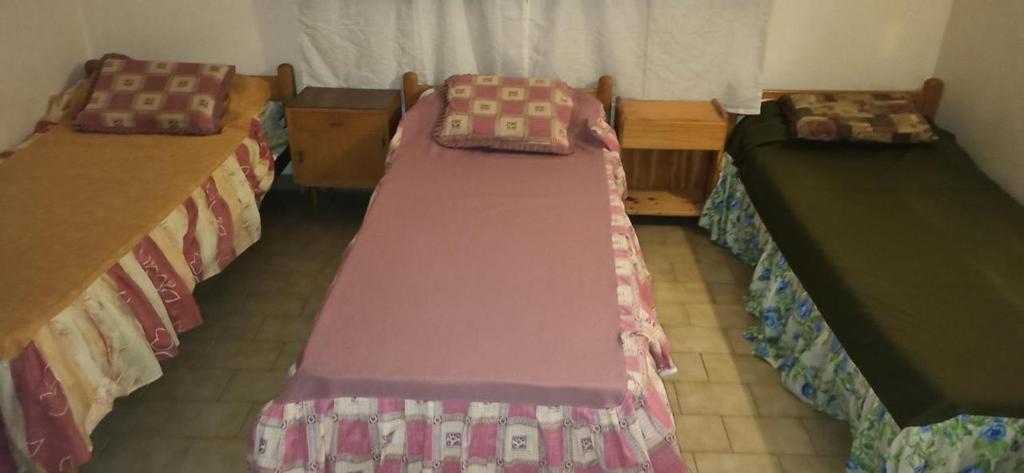 a room with two beds and two tables at Duplex 137 Gesell in Villa Gesell