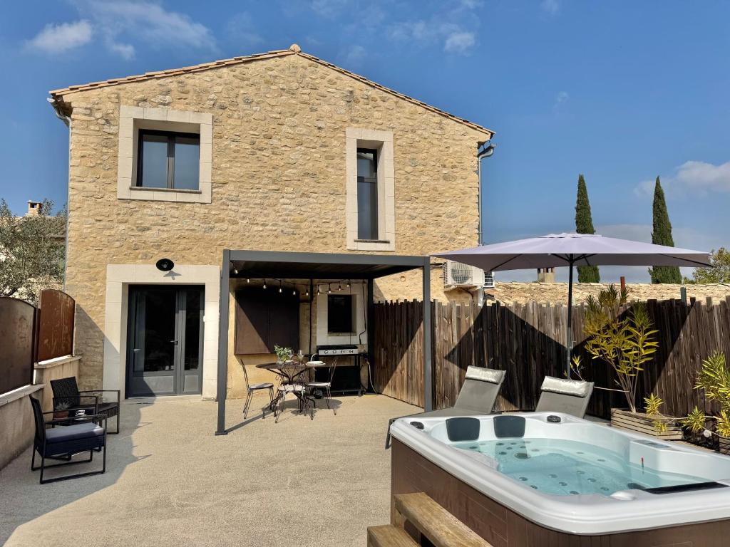 a backyard with a hot tub and a house at Gîte du Colombier in Crestet