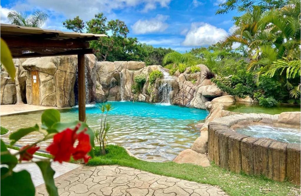 a pool of water with a waterfall in a garden at Pousada Caminho Das Cachoeiras in Sao Jorge