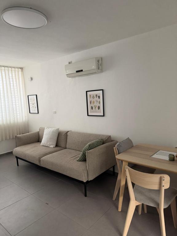 a living room with a couch and a table at The Urban Suite in Petaẖ Tiqwa