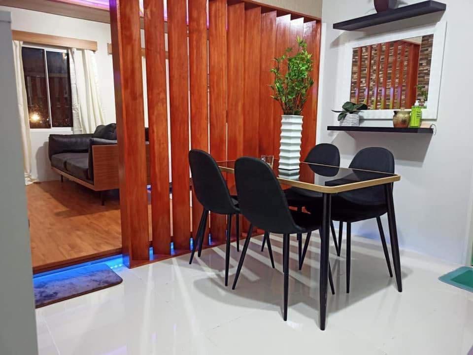 a dining room with a table and black chairs at Rye Lees Place in Bacolod