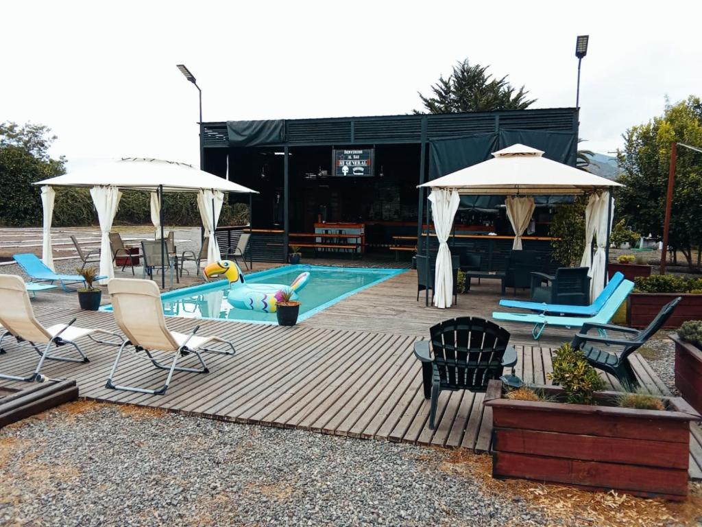 a patio with chairs and umbrellas next to a pool at El Rincon Secreto in Quillota