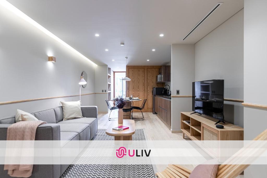 a living room with a couch and a tv at ULIV Antara in Mexico City