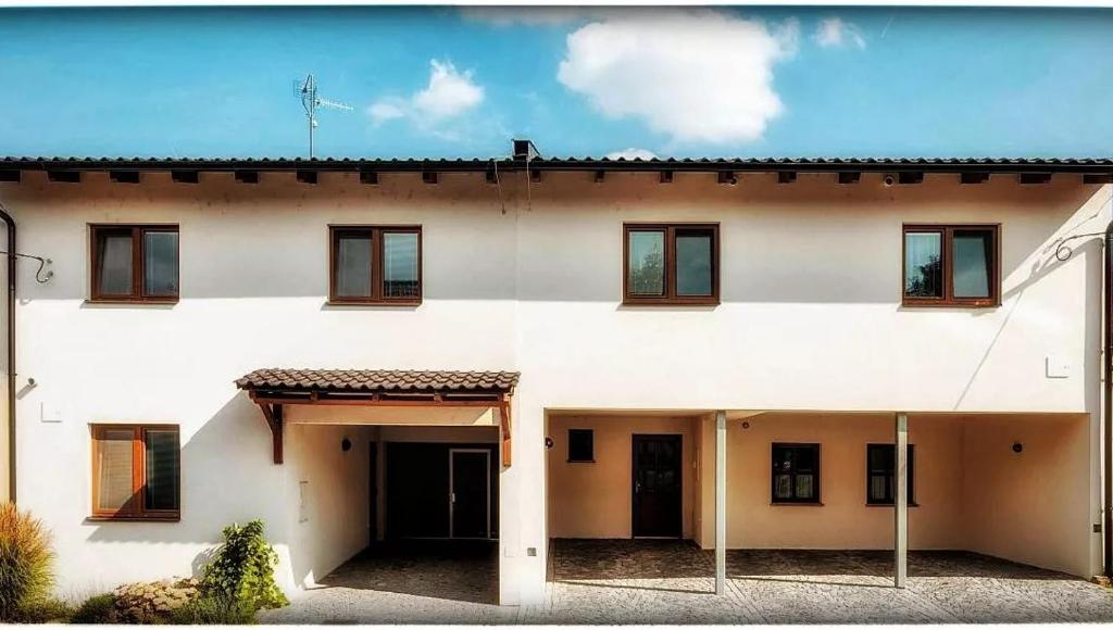 a white house with windows and a roof at Apartmány Pavlovice in Velké Pavlovice