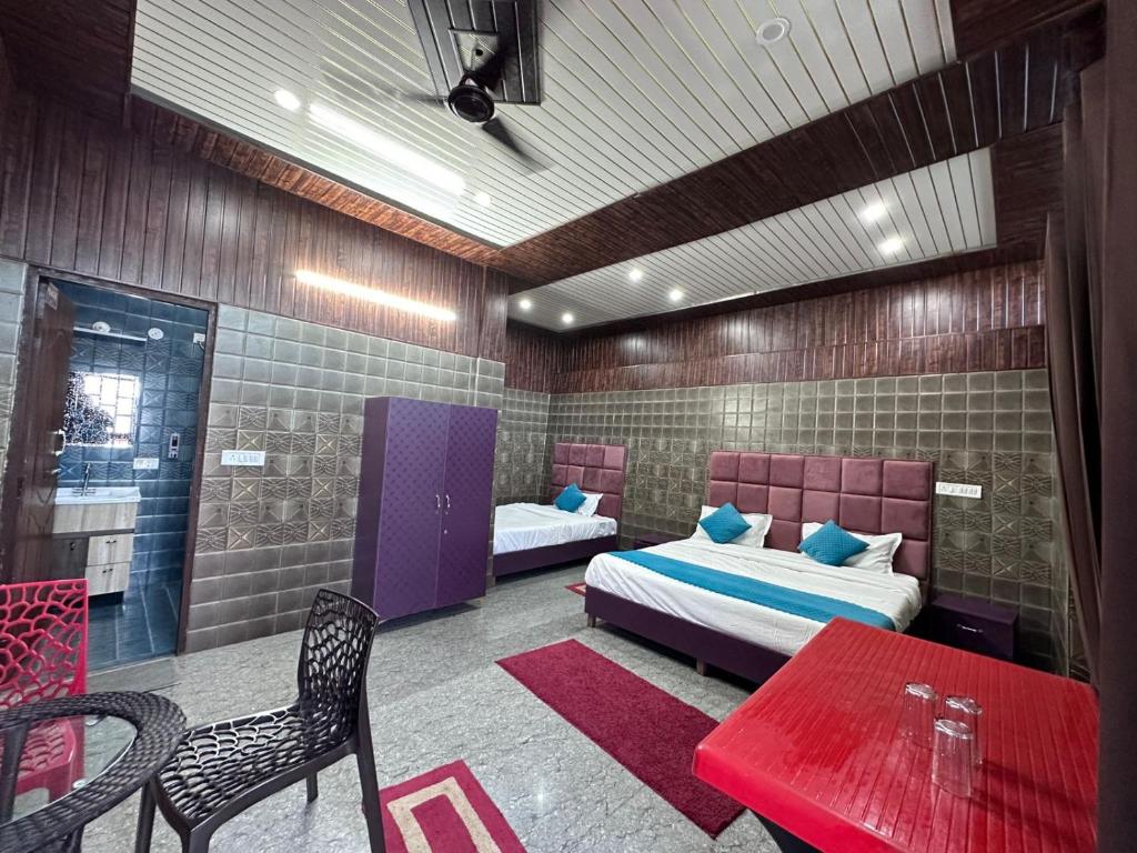 a bedroom with two beds and a table and chairs at Bella Vista Hotel & Home Stay in Mussoorie