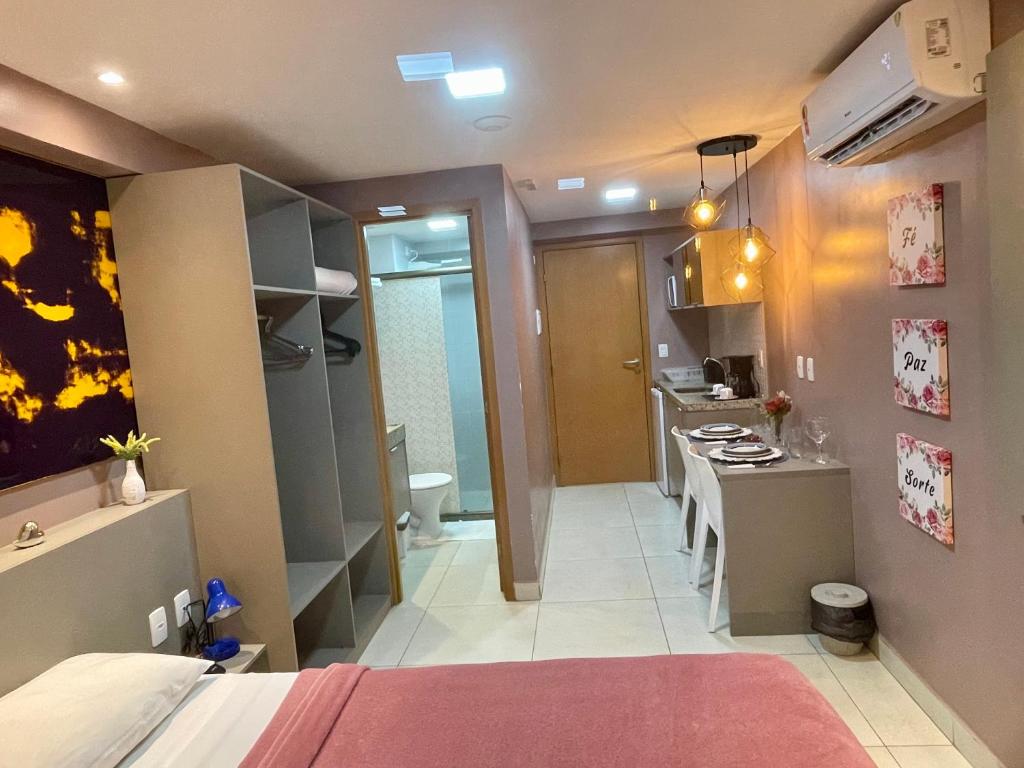 a room with a bed and a kitchen with a stove at Manaíra Apart Hotel - Flat 201 in João Pessoa