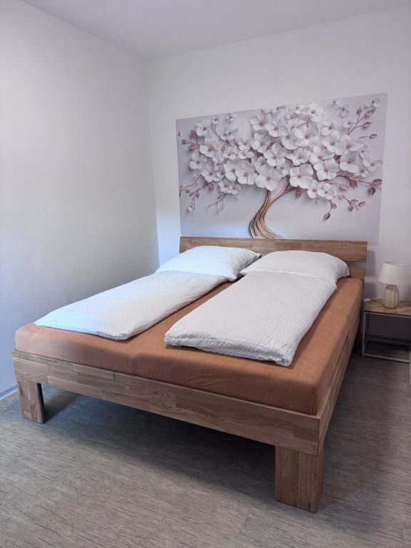 a bed in a room with a painting on the wall at Apartment Krajinka in Cheb