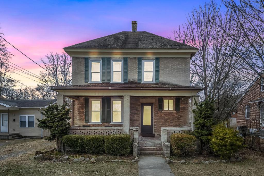 a brick house with a black roof at Broadway Cottage - Town, Hot Tub, Fire Pit, Grill, Wifi, Family Friendly, Pet Friendly in Berkeley Springs