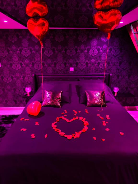 a bedroom with a bed with hearts on it at Loveroom LovaLova in Reims