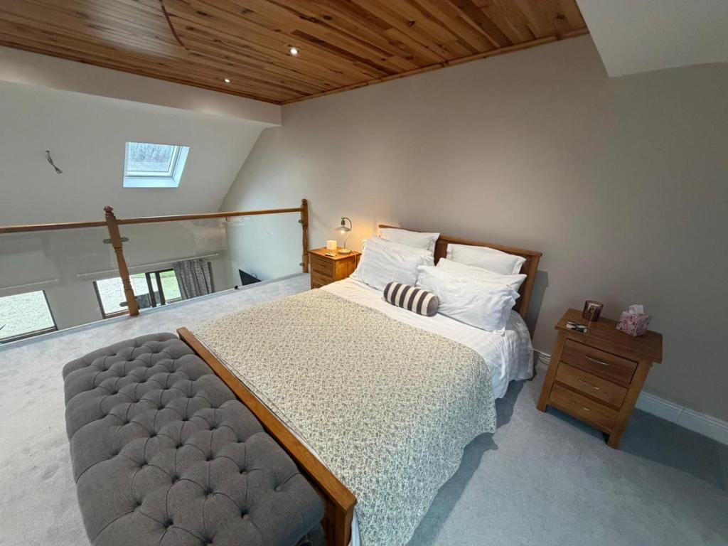 a bedroom with a large bed and a wooden ceiling at Sessaigh lake studio in Dunfanaghy
