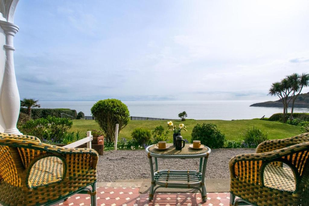 a patio with two chairs and a table with a view of the ocean at 2 Bed in Langland oc-hh142 in Newton