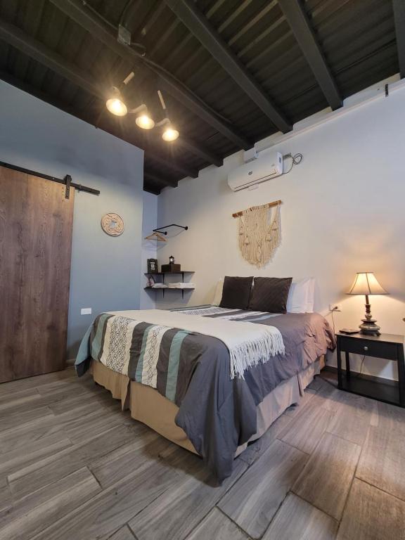 a bedroom with a large bed and a wooden floor at Estación 1501 - Casco histórico I in Juticalpa