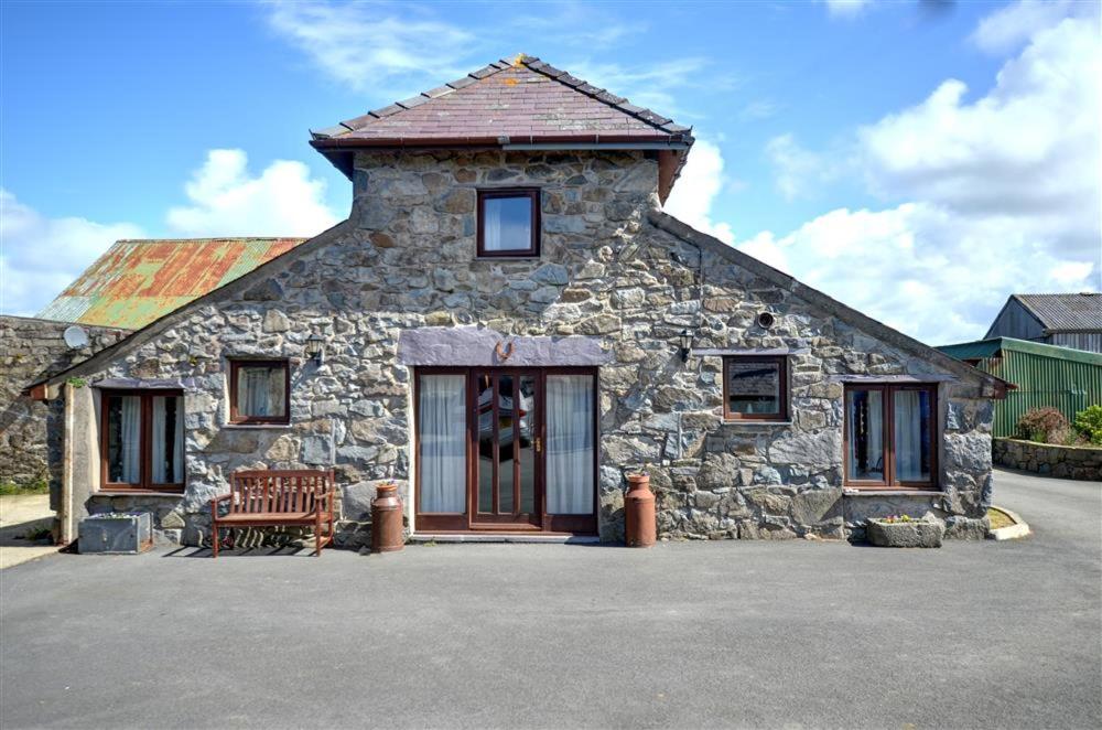 a stone house with a bench in front of it at 2 Bed in Caernarfon oc-wag263 in Llandegfan