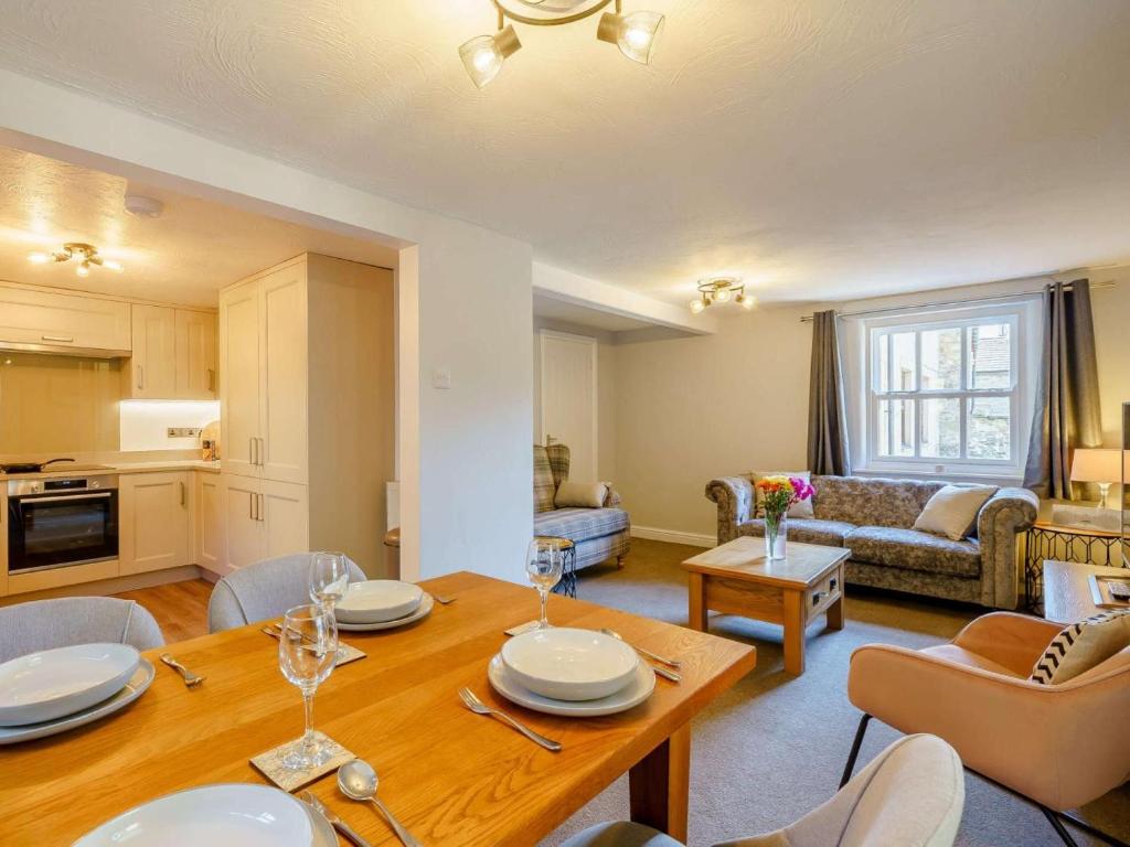 a living room with a wooden table and a kitchen at 2 Bed in Sedbergh oc-89266 in Milnthorpe