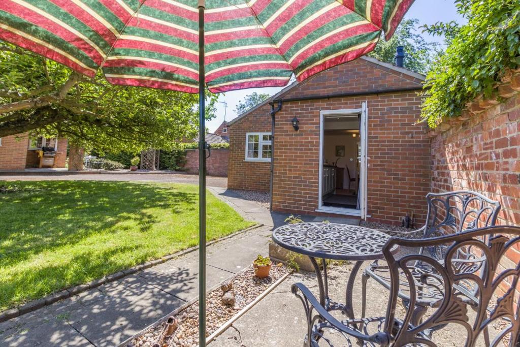 a patio table with an umbrella in a yard at 1 Bed in Halam oc-o32227 in Edingley