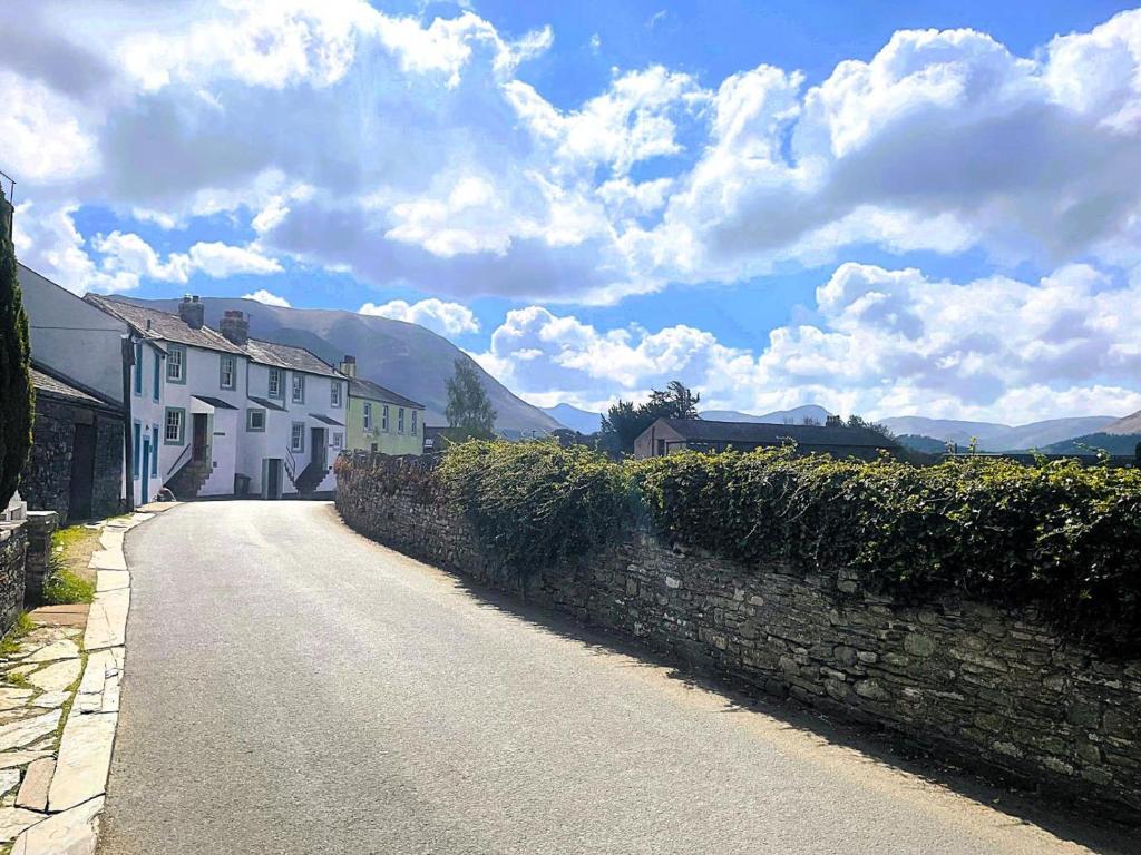 a street with houses and a stone wall at 2 Bed in Cockermouth oc-86023 in Lorton