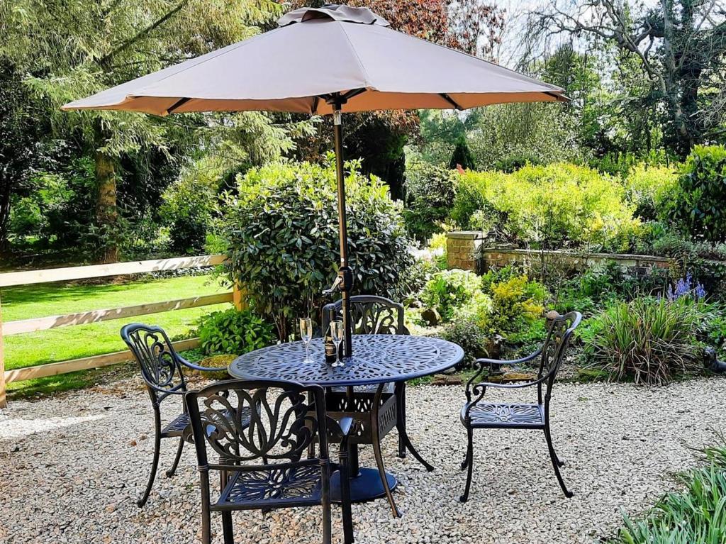 a table and chairs with an umbrella in a garden at 2 Bed in Alford oc-94226 in Great Carlton