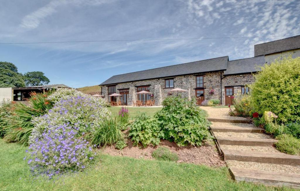 a stone house with a garden in front of it at 2 Bed in Tiverton oc-cide in Bampton