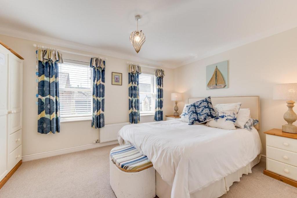 a bedroom with a large white bed and windows at 2 Bed in Seaton oc-mbtuc in Seaton