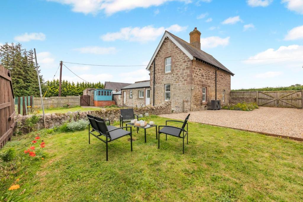 a yard with chairs and a table in front of a building at 2 Bed in Berwick-upon-Tweed oc-l32027 in Kyloe