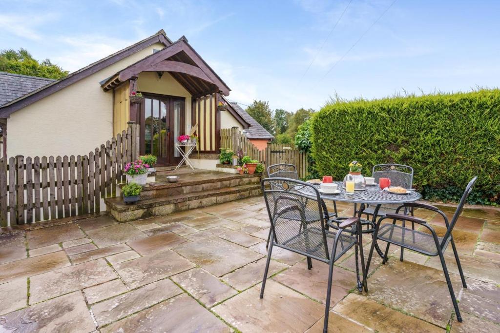 a patio with a table and chairs in front of a house at 2 Bed in Trallong oc-bow106 in Sennybridge