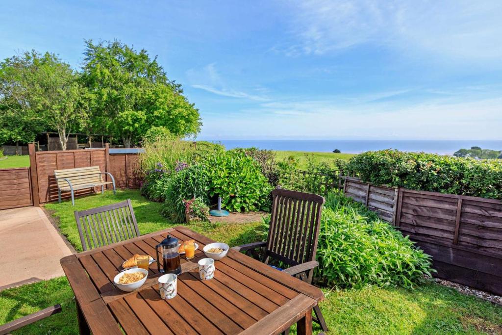 a wooden table and chairs in a yard at 1 Bed in Blue Anchor oc-b28904 in Blue Anchor