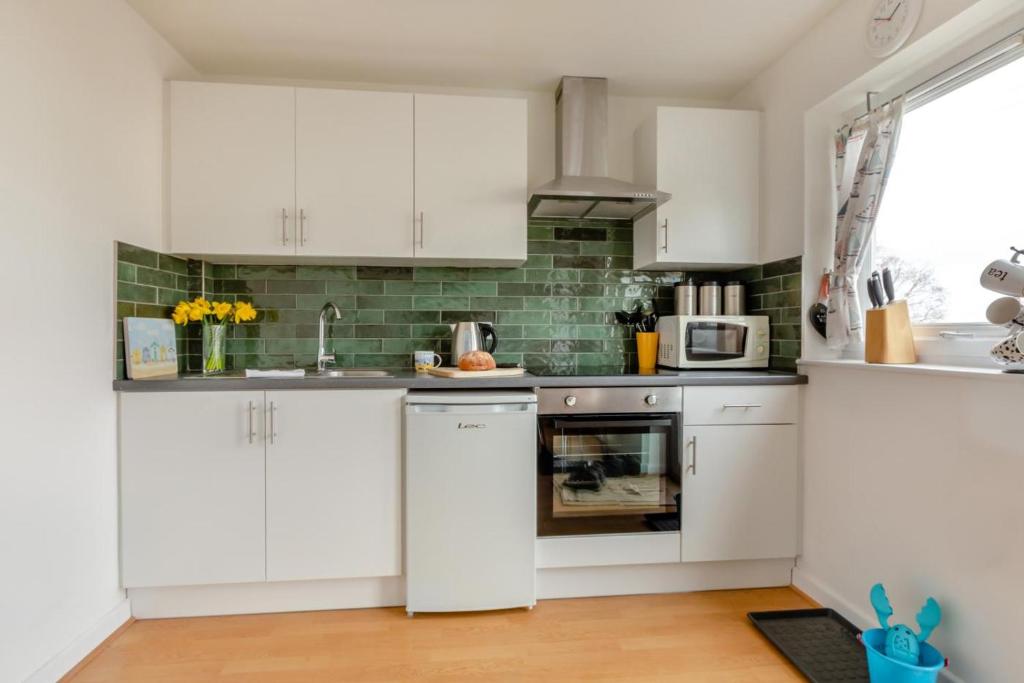 a kitchen with white cabinets and a microwave at 2 Bed in Brixham oc-f28884 in Brixham