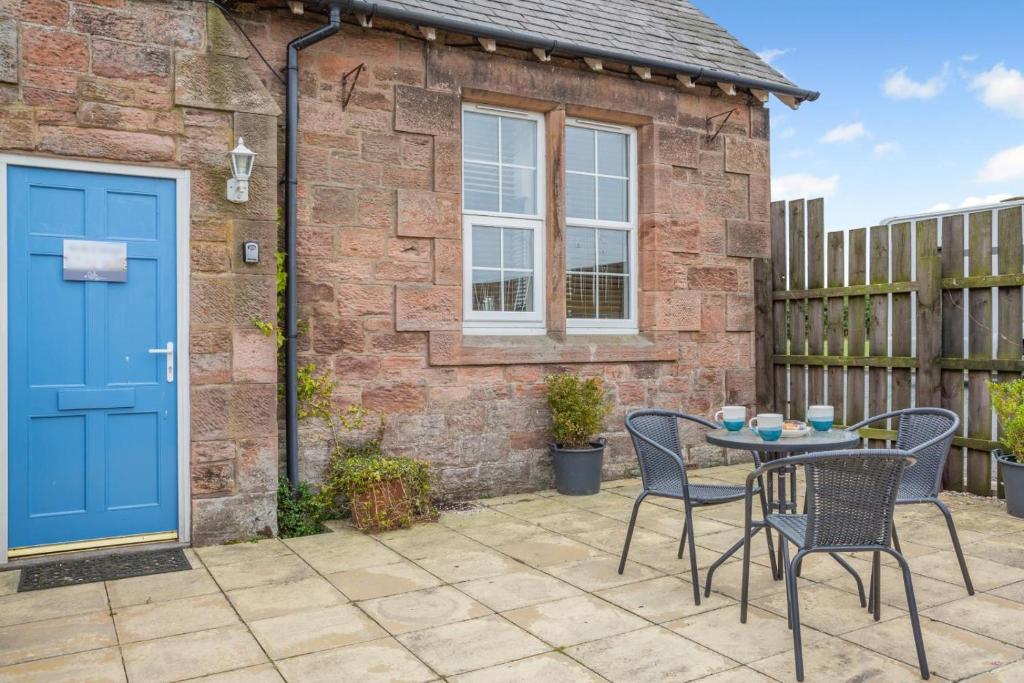 a patio with a blue door and chairs and a table at 1 Bed in Berwick-upon-Tweed oc-b32029 in Kyloe