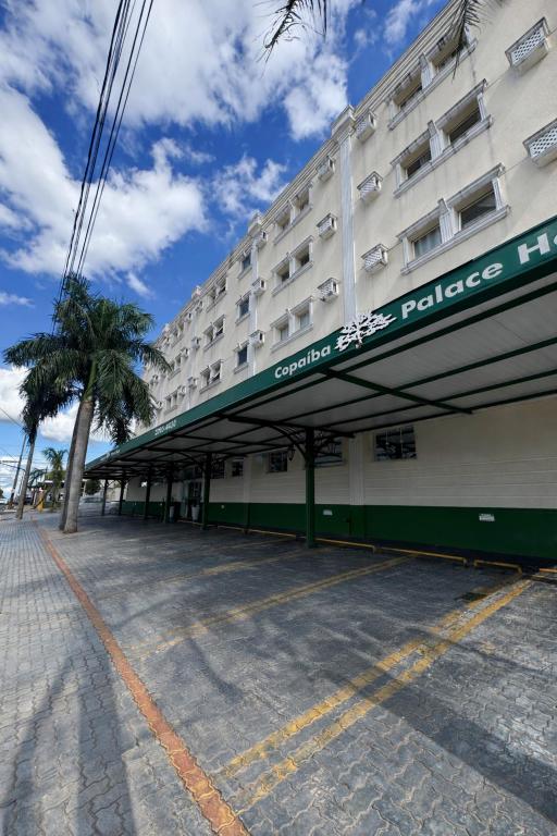 a large hotel with a police building and a palm tree at Copaiba Palace Hotel in Bauru