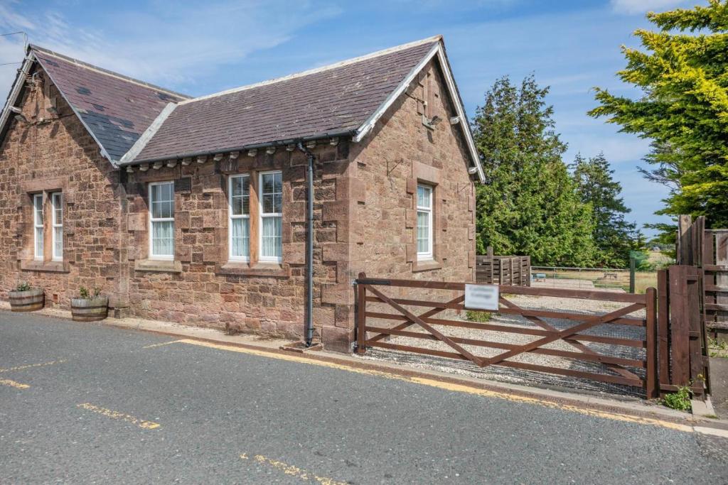 a brick house with a wooden gate and a fence at 1 Bed in Berwick-upon-Tweed oc-c32028 in Kyloe