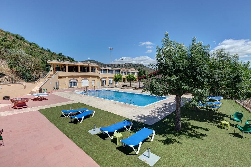 a swimming pool with lounge chairs and a house at Alberg Montsec-Mur in Guardia de Tremp
