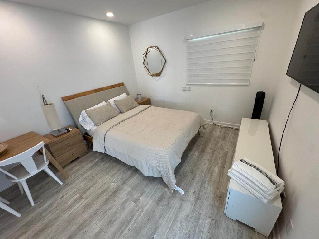 a bedroom with a bed and a desk and a television at Central location in Cutler Bay