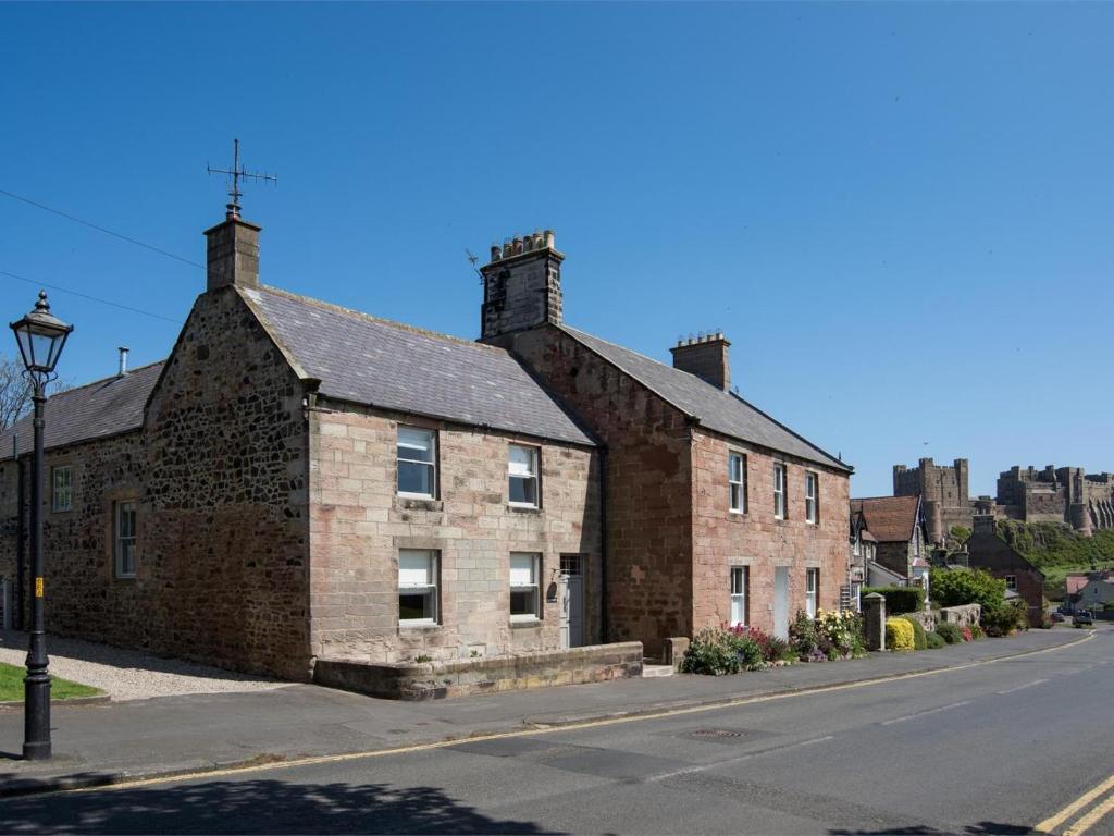 an old brick building on the side of a street at 4 Bed in Bamburgh oc-cn089 in Bamburgh
