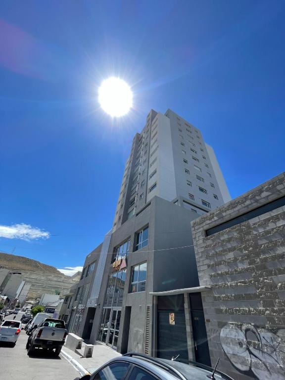 a tall building with the sun in the sky at Monoambiente Centro in Comodoro Rivadavia