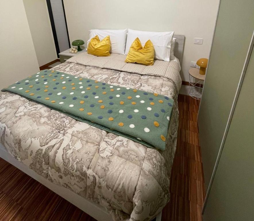 a bed with yellow pillows and a green blanket on it at Il Piccolo Scrigno 2 in Lonigo