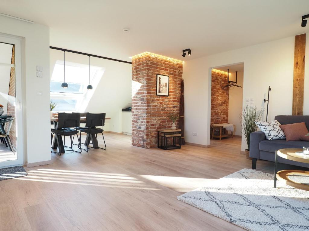 a living room with a couch and a brick wall at "Dat Nordische Huus" - Hyggelig, mit Fußbodenheizung, Balkon, Glasfaser-Internet und Wallbox in Beverstedt