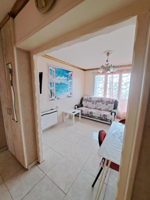 a living room with a couch and a table at l'ESCALE à 50 m de la gare de viry chatillon in Viry-Châtillon