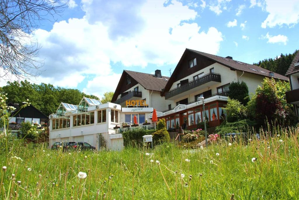 a large white building in a field of grass at Landhotel Püster in Allagen