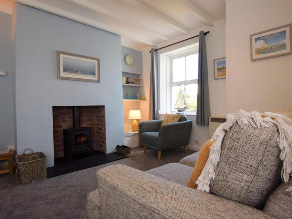 a living room with a couch and a fireplace at 1 Bed in Seahouses oc-cn123 in Seahouses