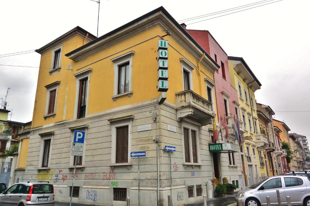 un edificio amarillo con un cartel en el costado en Hotel Trentina, en Milán