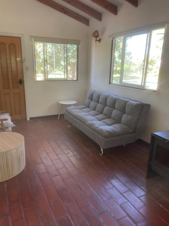 a living room with a couch and two windows at Hermosa Cabaña en Limache in Lo Narváez