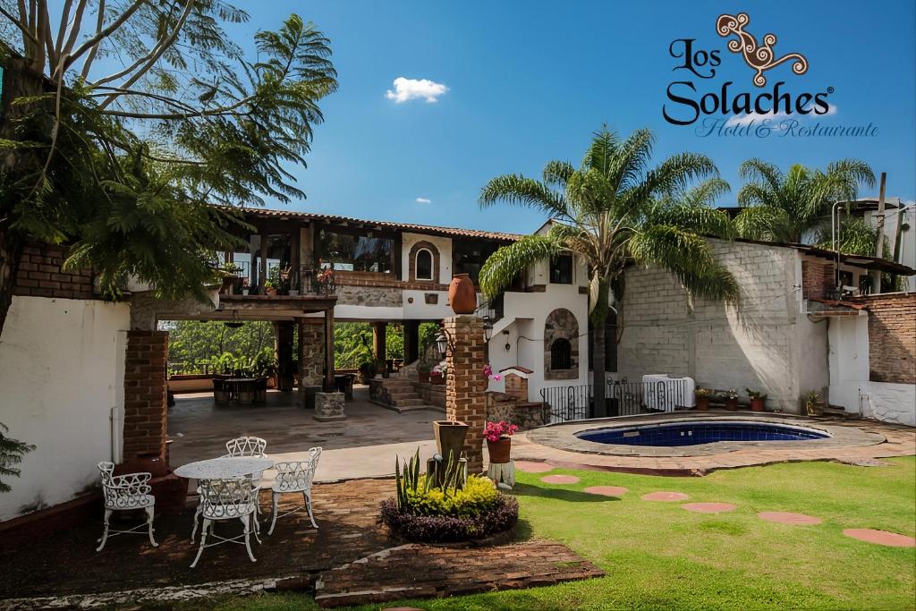 a patio with a table and chairs in a yard at HOTEL & RESTAURANTE Los solaches in Zitácuaro