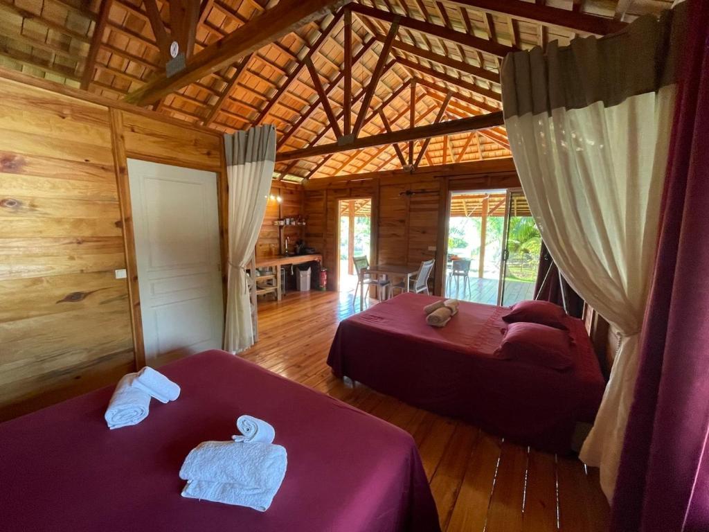 a room with two beds in a log cabin at Lodge ORION - Coté Piscine in Uturoa